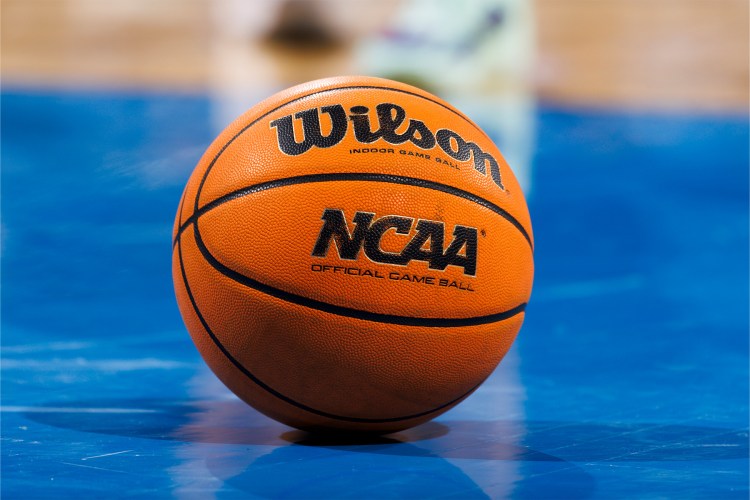 An NCAA basketball sits on the court during March Madness NCAA tournament