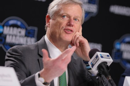 NCAA President Charlie Backer answers questions in front of a microphone during the 2024 NCAA Tournament