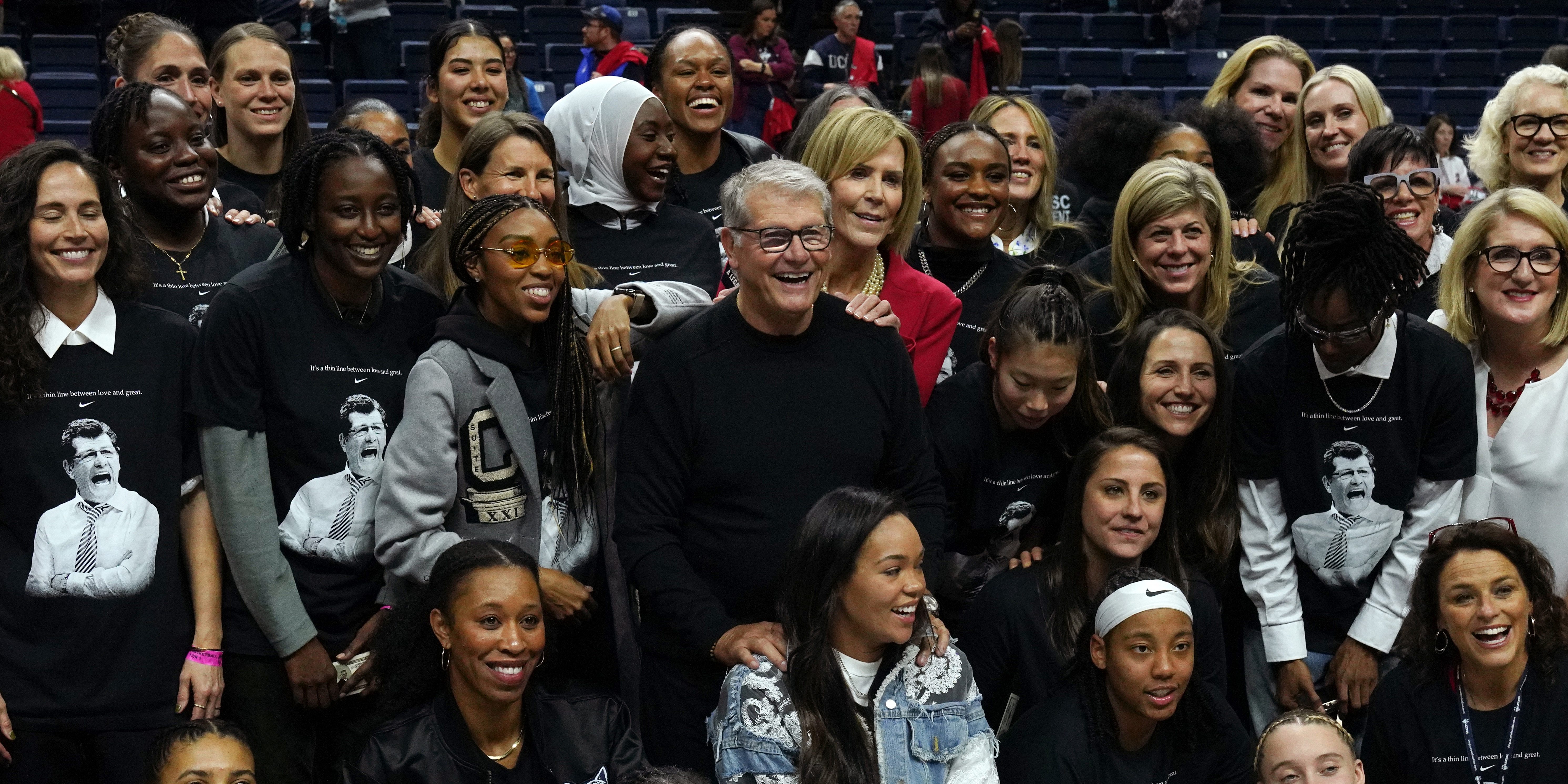 UConn coach Geno Auriemma is surrounded by former players after becoming the all-time wins leader in college basketball.