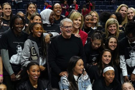 UConn coach Geno Auriemma is surrounded by former players after becoming the all-time wins leader in college basketball.