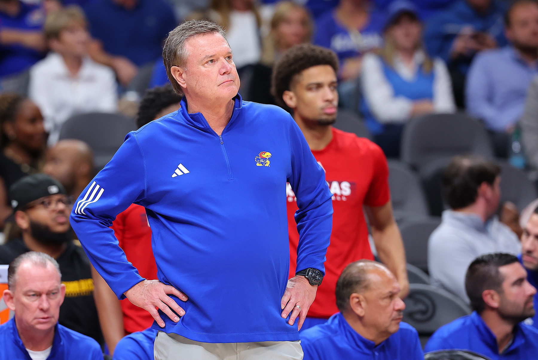 Bill Self stands on the sidelines with his hands on his hips during a game.