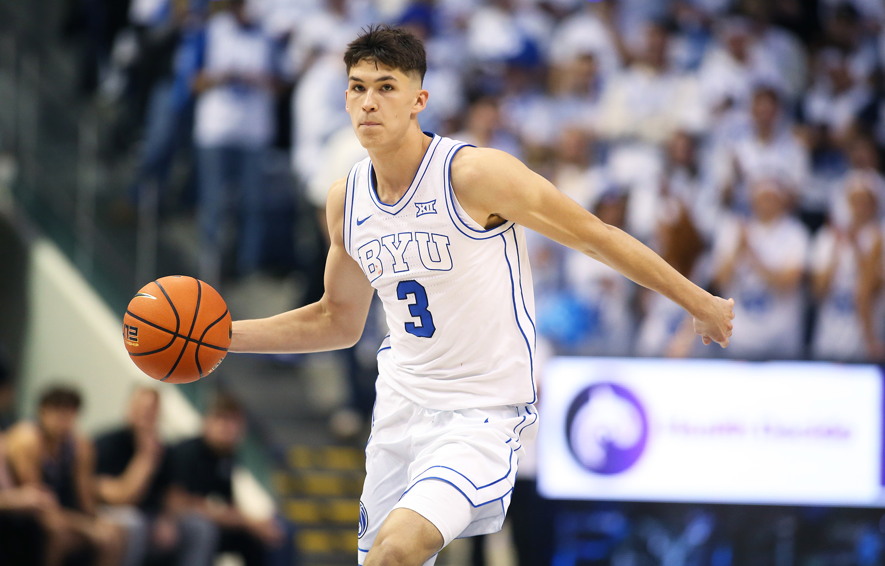 BYU guard Egor Demin holds the ball in one hand about to throw a pass during a game.