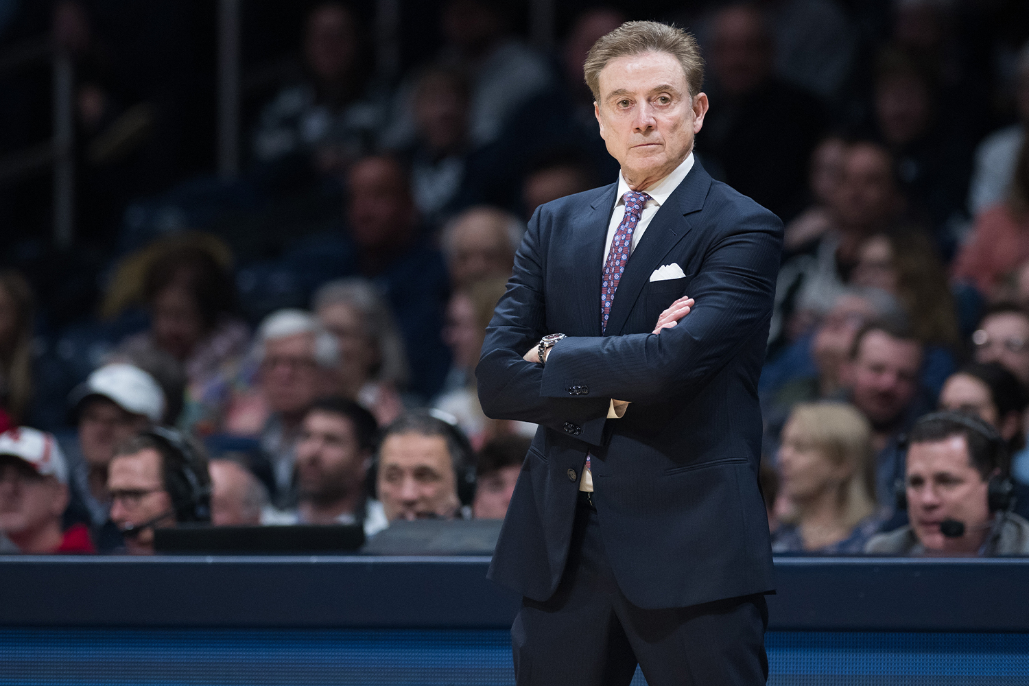 St. John's coach Rick Pitino watches a game from the sideline with his arms folded.