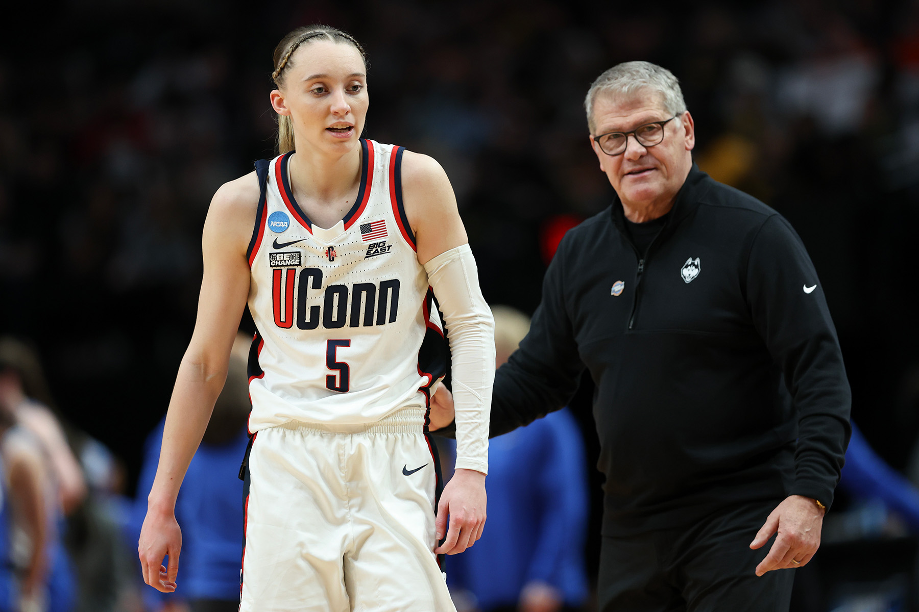 UConn guard Paige Bueckers and head coach Geno Auriemma standing next to each other during a game.