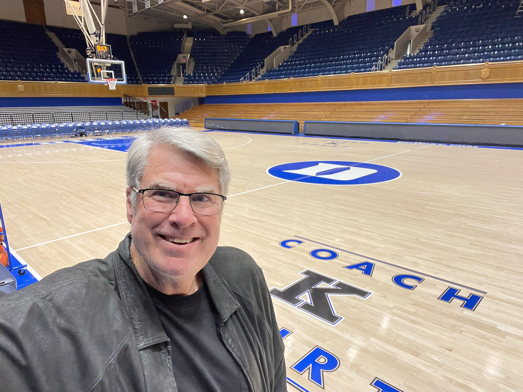 Mike Gminski in a selfie in front of Coach K court at Duke.