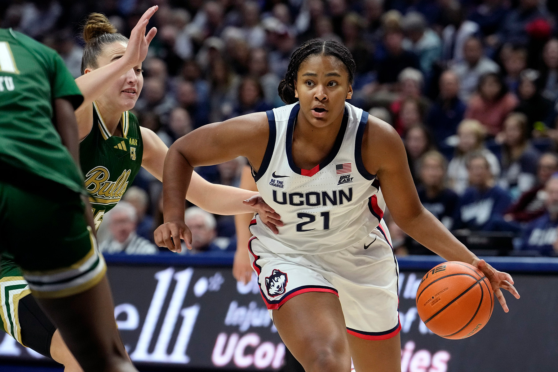 UConn freshman Sarah Strong dribbles the ball with her left hand as a defender tries to keep up.