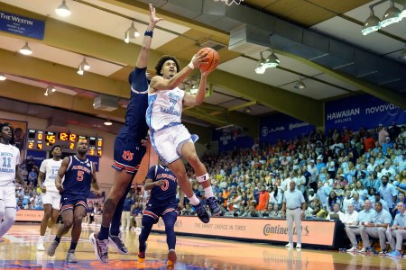 UNC guard Seth Trimble soars through the air for a layup as a defender tries to block him.