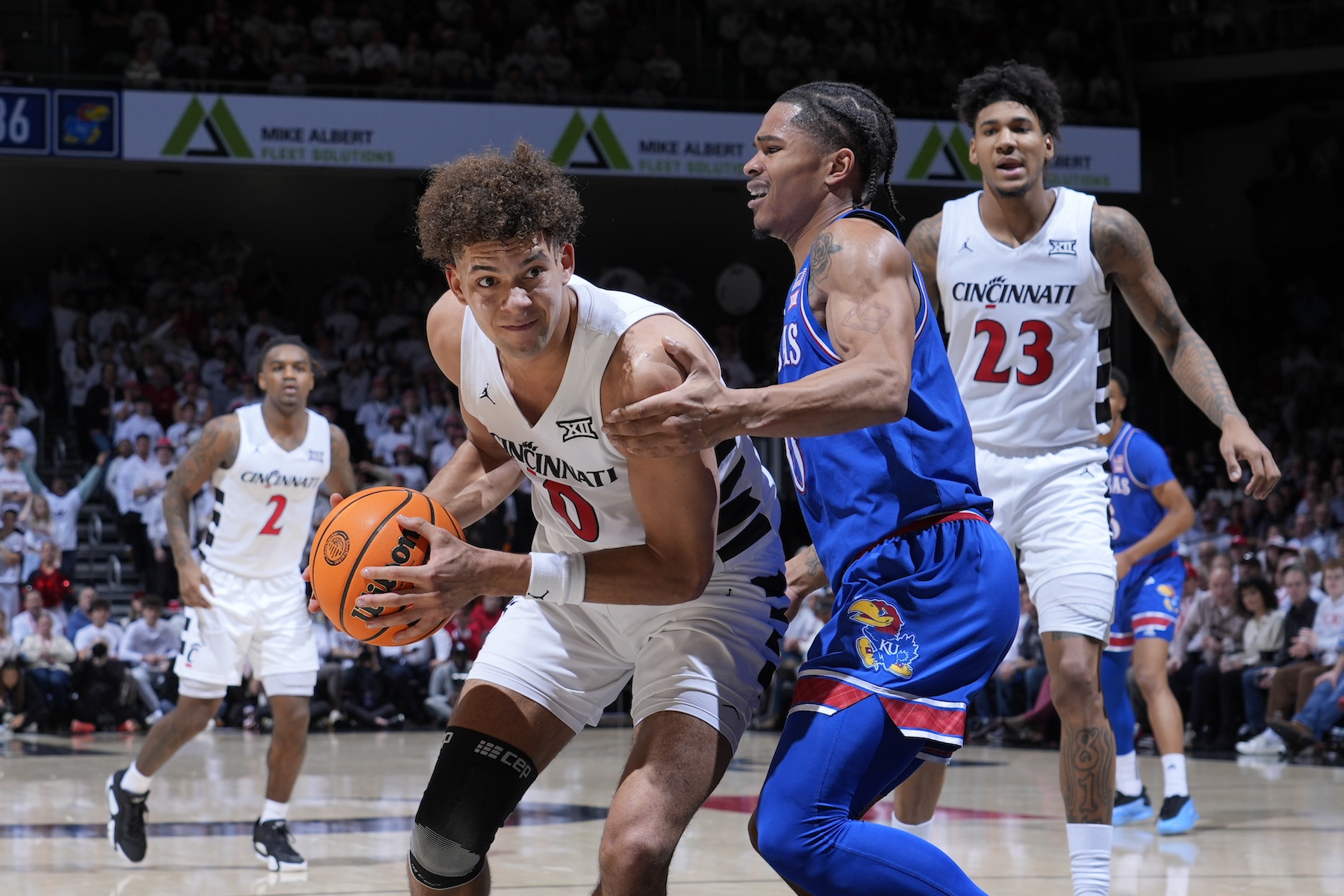 Cincinnati Bearcats guard Dan Skillings Jr. (0) drives to the basket while defended by Kansas Jayhawks guard Shakeel Moore