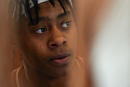 Tre Johnson (20) can be seen between players while in the huddle during a timeout