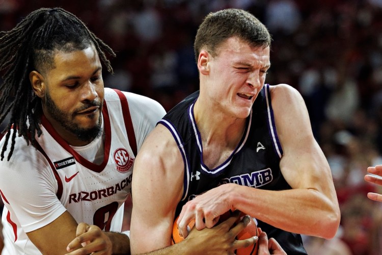 Jacob Ognacevic #41 of the Lipscomb Bison drives to the basket against Jonas Aidoo #9 of the Arkansas Razorbacks